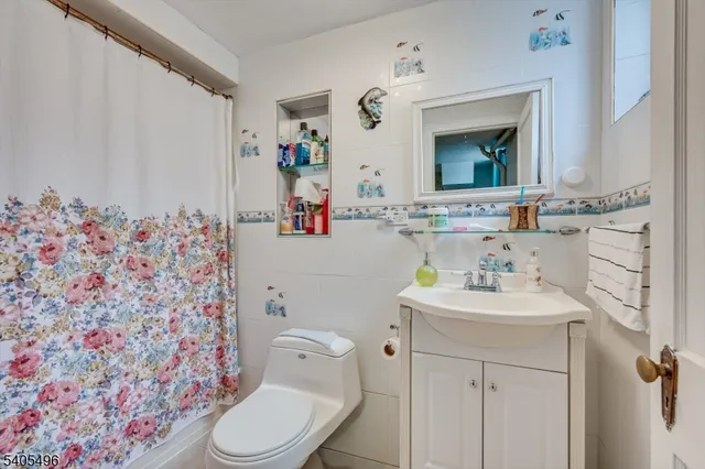 a bathroom with a sink mirror vanity and toilet
