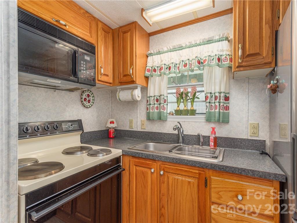 258 Mallard Loop Waynesville, NC 28785 - Photo 11 of 22 a kitchen with stainless steel appliances granite countertop a sink stove and cabinets