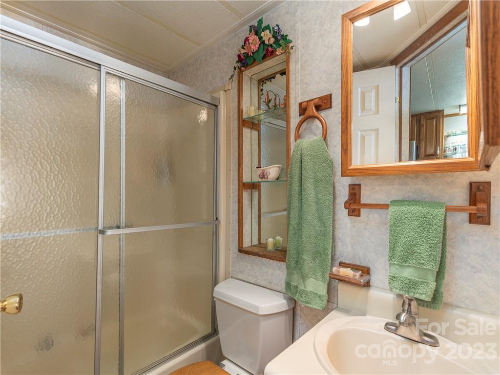 258 Mallard Loop Waynesville, NC 28785 - Photo 12 of 22 a bathroom with a granite countertop toilet sink and shower
