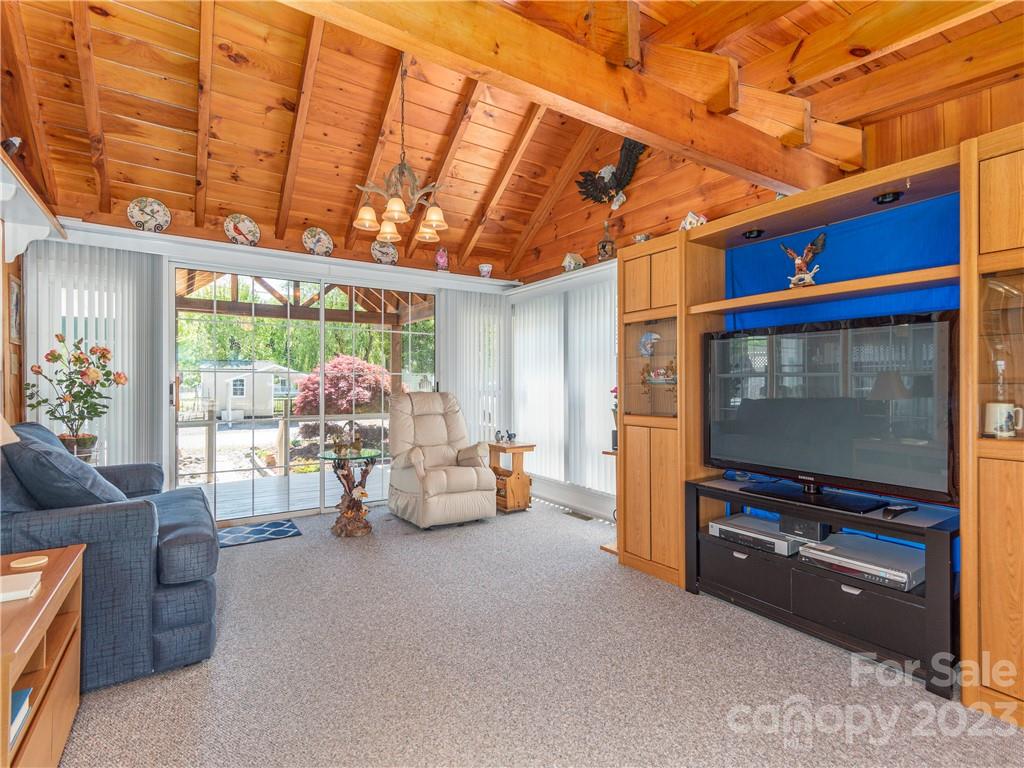 258 Mallard Loop Waynesville, NC 28785 - Photo 5 of 22 a living room with furniture a flat screen tv and a floor to ceiling window