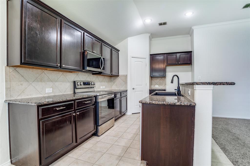 513 Wichita Trail McKinney, TX 75071 - Photo 2 of 12 a kitchen with stainless steel appliances granite countertop a stove a sink and a microwave
