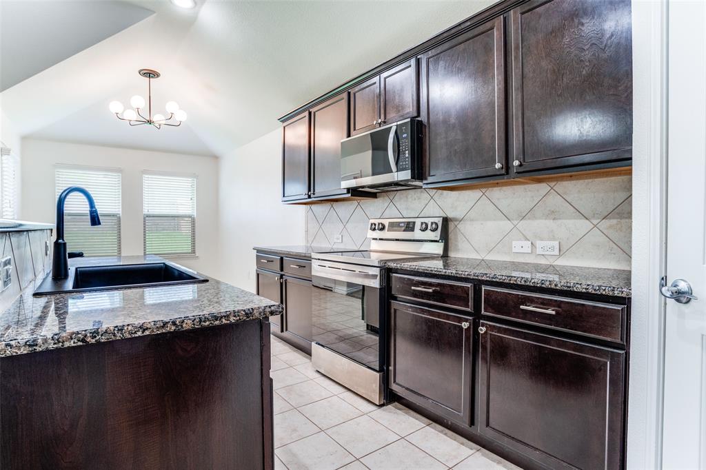513 Wichita Trail McKinney, TX 75071 - Photo 3 of 12 a kitchen with stainless steel appliances granite countertop a stove a sink and a microwave