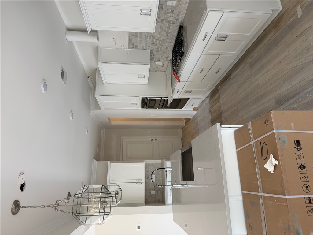 405 Botany Lane Anderson, SC 29621 - Photo 7 of 14 This spacious kitchen features sleek cabinetry, a large island, and modern appliances for daily living.