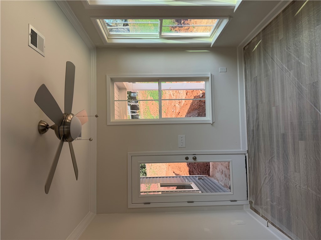 405 Botany Lane Anderson, SC 29621 - Photo 9 of 14 This bright space features a unique wall-mounted ceiling fan and skylights, creating an inviting atmosphere.