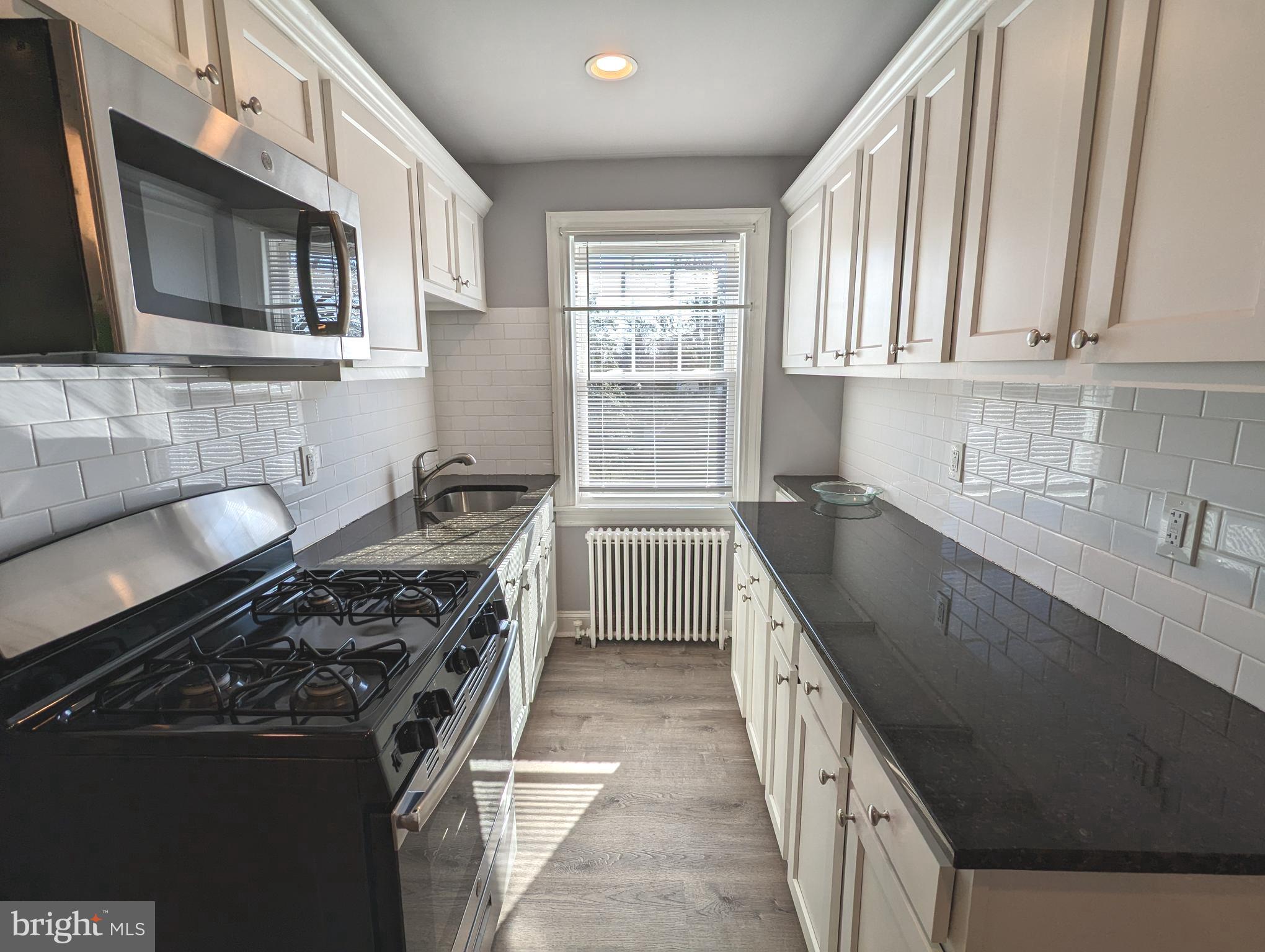401 Montgomery Street, Unit 2 Laurel, MD 20707 - Photo 4 of 13 a kitchen with stainless steel appliances a sink stove and cabinets