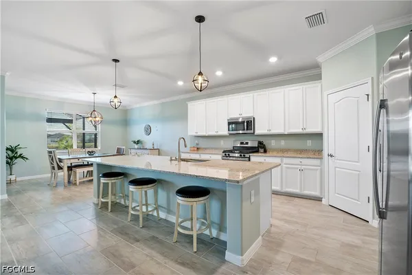 a kitchen with cabinets and chairs