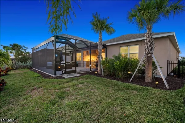 a view of a house with a yard and palm trees
