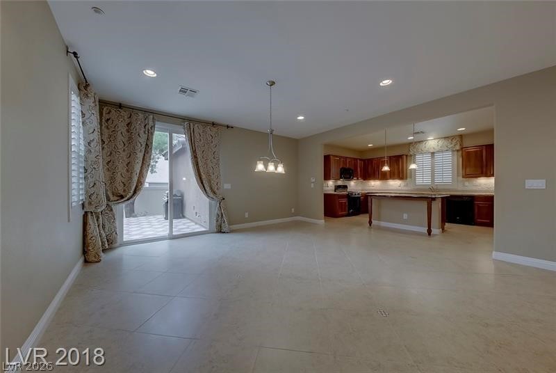 3144 Whitfeild Avenue Henderson, NV 89044 - Photo 54 of 55 An open floorplan seamlessly connects the well-appointed kitchen with an airy living area, featuring tile flooring and abundant natural light.