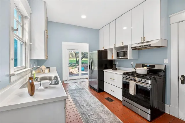 a kitchen with a sink a stove and cabinets