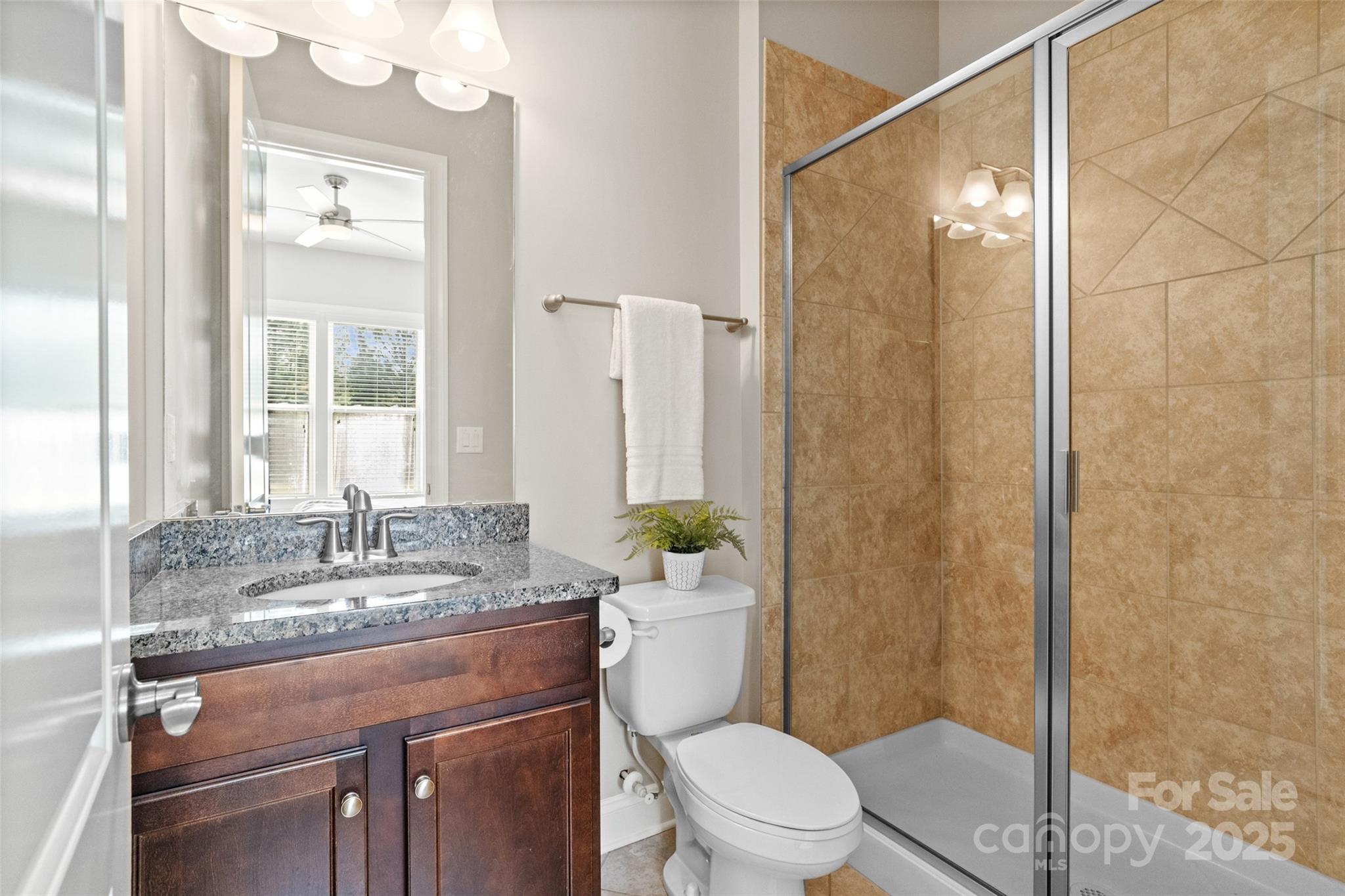 1022 Torrens Drive Monroe, NC 28110 - Photo 36 of 46 a bathroom with a granite countertop sink a toilet a mirror and shower