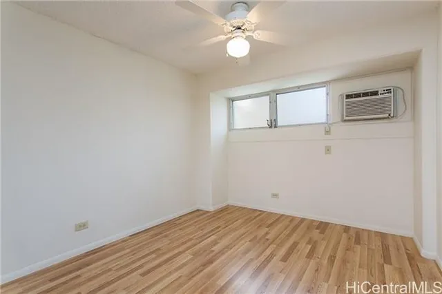 a view of a room with wooden floor and ceiling fan