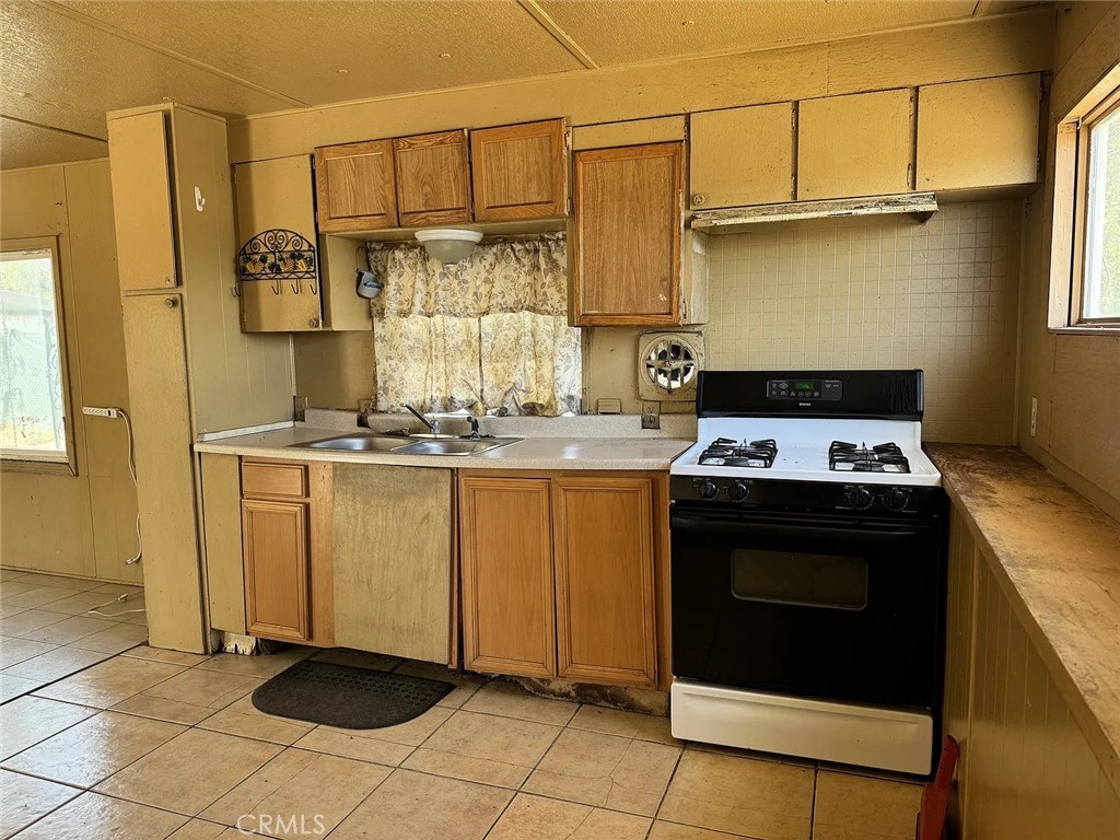 640 Apache Road Perris, CA 92570 - Photo 4 of 10 a kitchen with stainless steel appliances granite countertop a stove a refrigerator and a sink