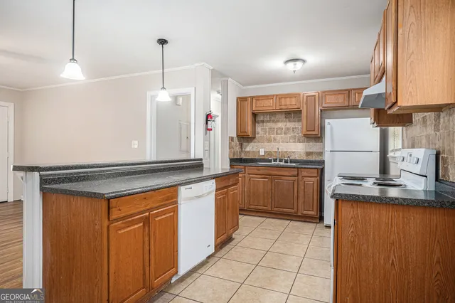 a kitchen with stainless steel appliances granite countertop a stove a sink and a refrigerator