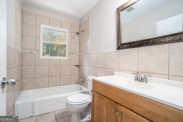 a bathroom with a sink a toilet a mirror and bathtub