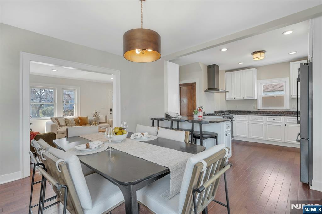 39 Vernon Terrace Bloomfield, NJ 07003 - Photo 14 of 39 a open dining room with stainless steel appliances kitchen island granite countertop a table and chairs with wooden floor
