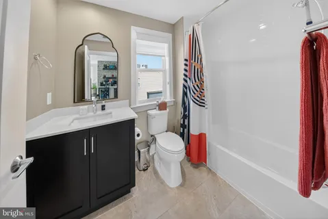 a living room with furniture a flat screen tv and floor to ceiling window