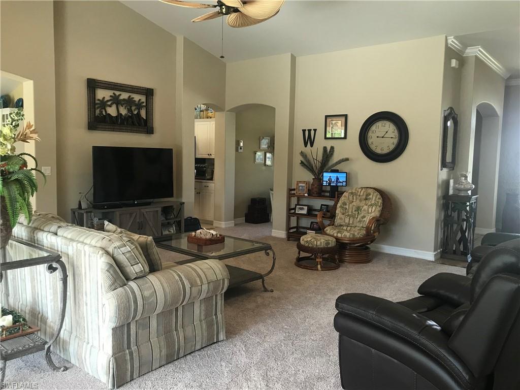 120 Forest Hills Boulevard Naples, FL 34113 - Photo 2 of 24 a living room with furniture a couch and a flat screen tv