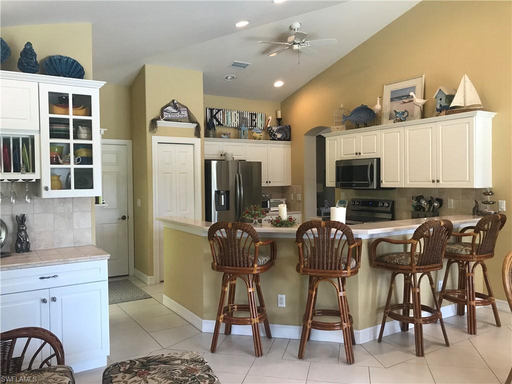120 Forest Hills Boulevard Naples, FL 34113 - Photo 5 of 24 a kitchen with stainless steel appliances kitchen island granite countertop a refrigerator and microwave
