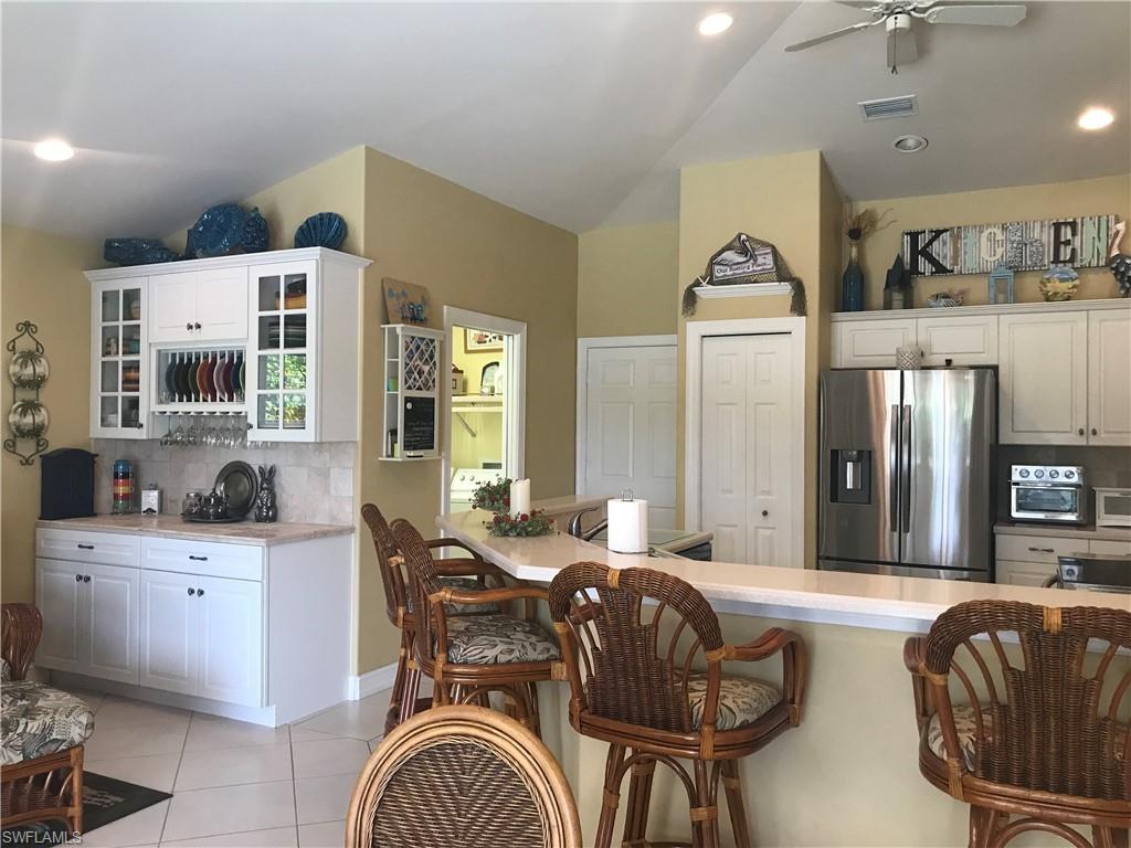 120 Forest Hills Boulevard Naples, FL 34113 - Photo 6 of 24 a living room with furniture a large window and gym equipment