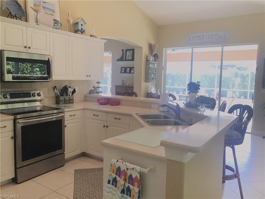 120 Forest Hills Boulevard Naples, FL 34113 - Photo 8 of 24 a kitchen with a stove a sink and a refrigerator