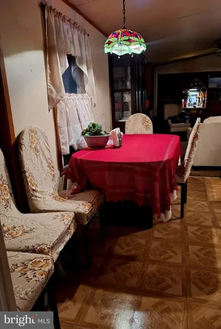 a view of a dining room with furniture a chandelier and window