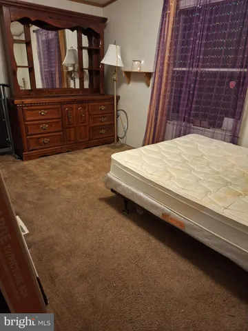 a bed sitting in a bedroom and mirror