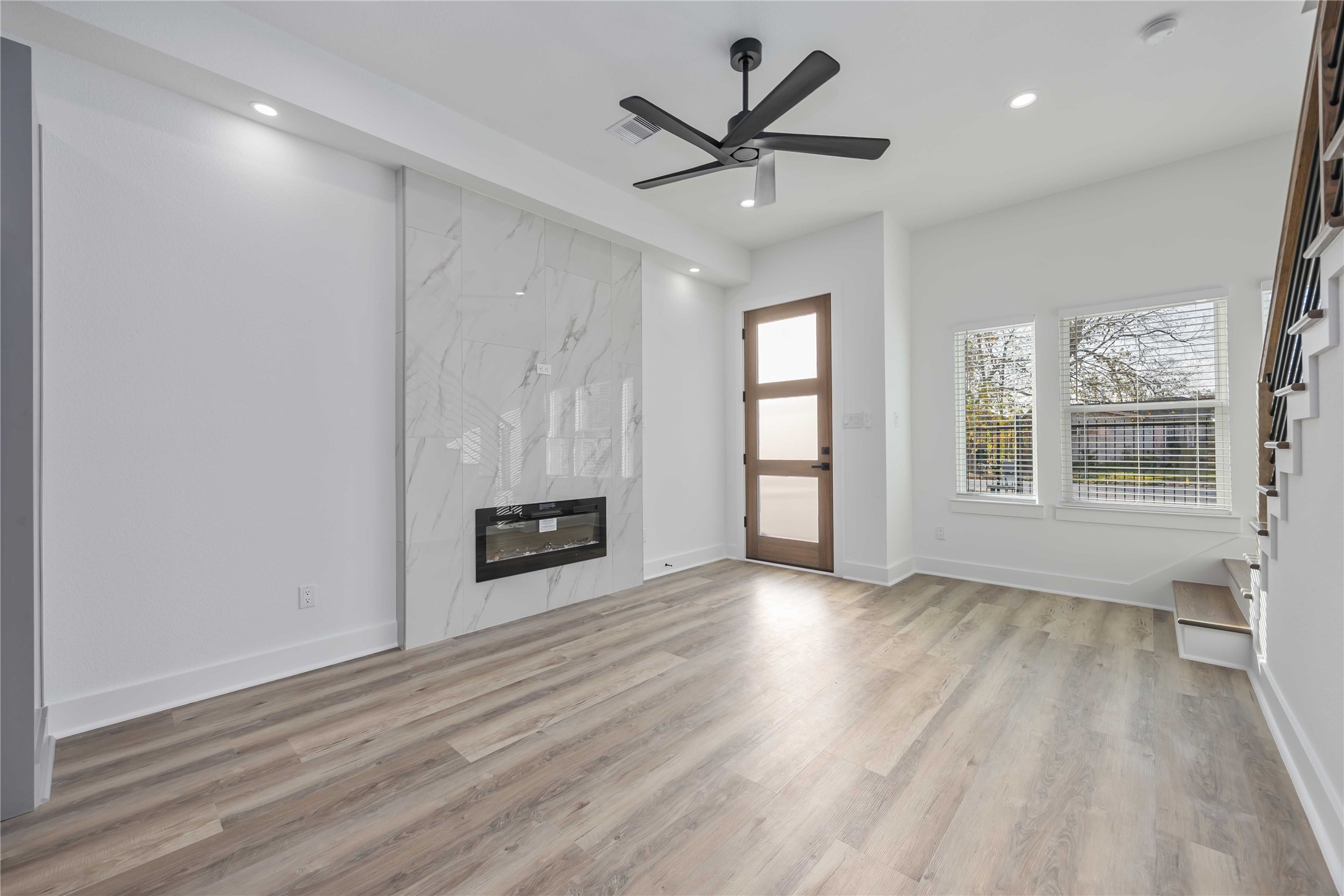4533 Larkspur Street, Unit B Houston, TX 77051 - Photo 7 of 36 an empty room with wooden floor a ceiling fan and windows