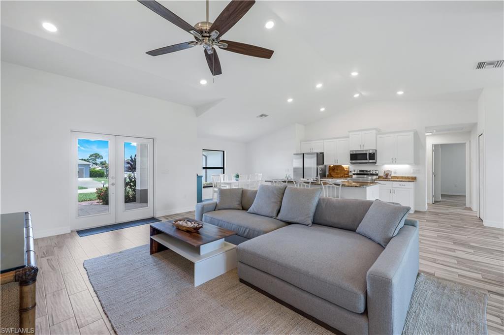 18209 Hawthorne Road Fort Myers, FL 33967 - Photo 3 of 23 Spacious open great room with recessed lighting, wood look tile, ceiling fan, volume ceilings, and glass front doors.