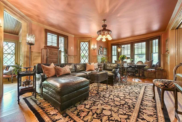 a living room with furniture chandelier and a large window