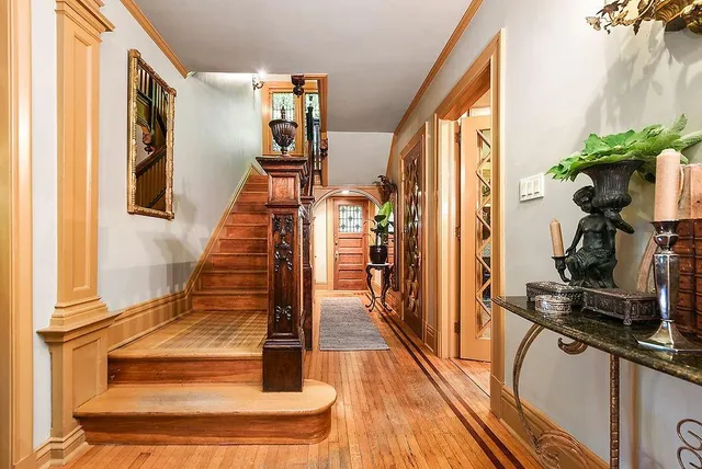 a view of a hallway with wooden floor and staircase