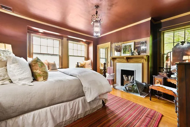 a spacious bedroom with a bed and wooden floor