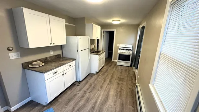 a kitchen with a refrigerator a stove top oven and a sink