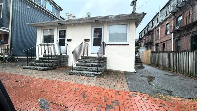 a view of a house with stairs and wooden fence