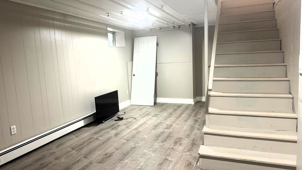 220 Hamilton Street, Unit TWNHS Cambridge, MA 02139 - Photo 9 of 11 a view of an empty room with wooden floor and a window