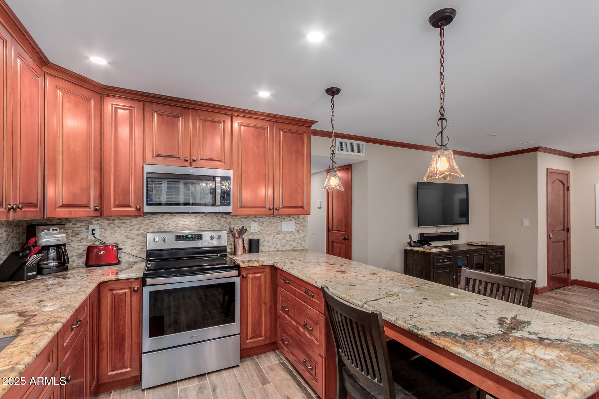 5525 East Thomas Road, Unit E3 Phoenix, AZ 85018 - Photo 12 of 34 a kitchen with kitchen island granite countertop a sink a counter top space appliances and cabinets