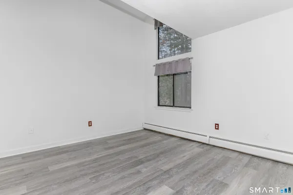 an empty room with wooden floor and white walls
