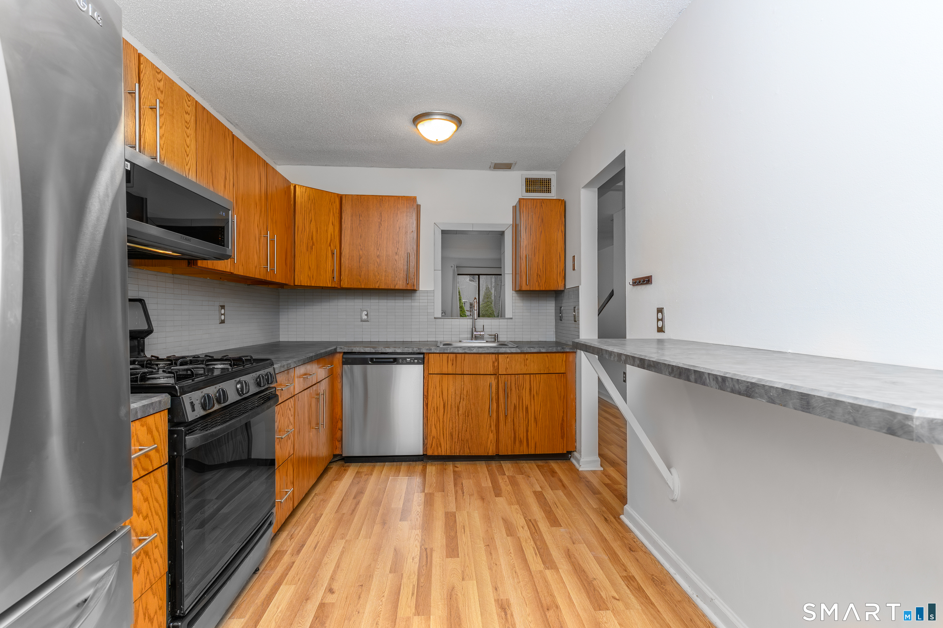 5 Talcott Forest Road, Unit A Farmington, CT 06032 - Photo 6 of 36 a kitchen with stainless steel appliances granite countertop a stove a sink and a microwave