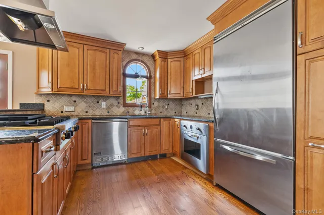 a kitchen with stainless steel appliances granite countertop a stove a sink and a refrigerator