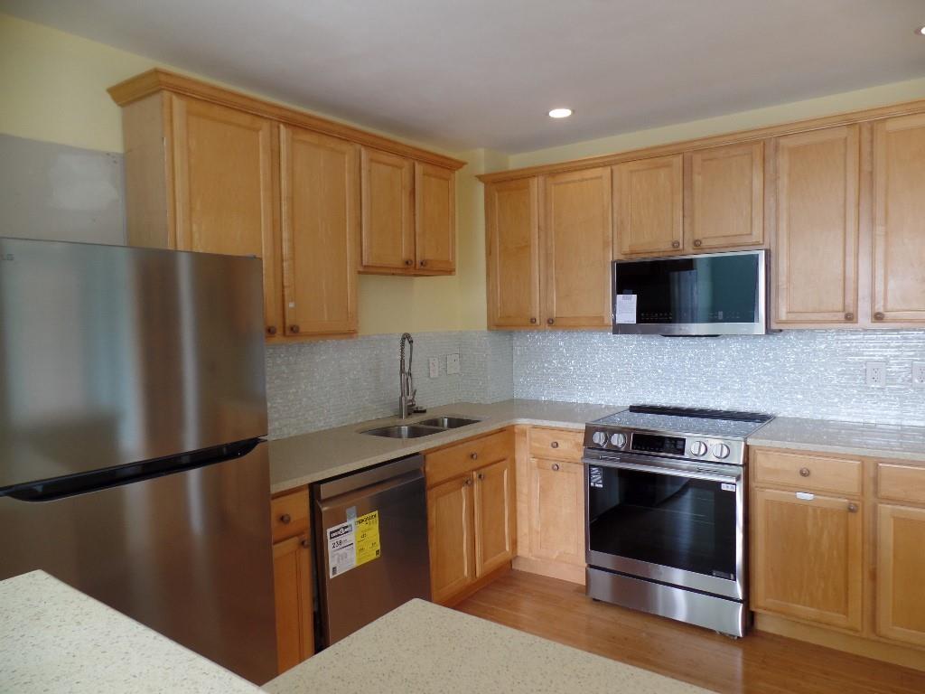 320 Fort Duquesne Boulevard, Unit 24M Pittsburgh, PA 15222 - Photo 4 of 40 a kitchen with stainless steel appliances granite countertop a stove a refrigerator and a microwave