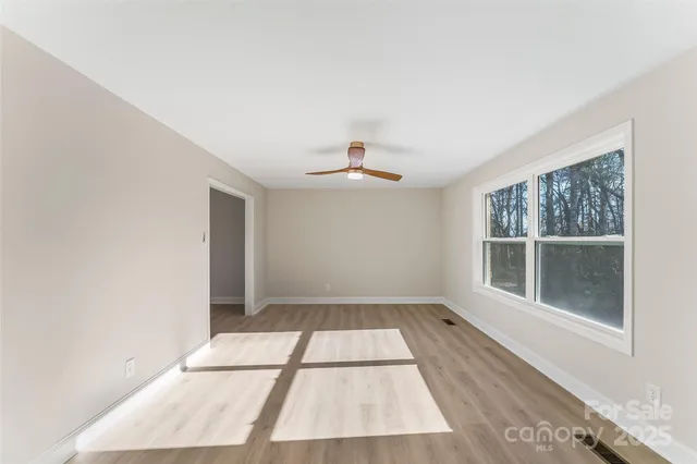 a view of a room with wooden floor and a hallway