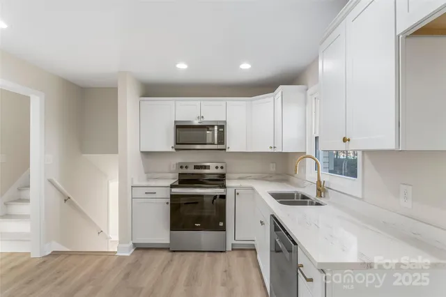 a kitchen with a sink stainless steel appliances and cabinets