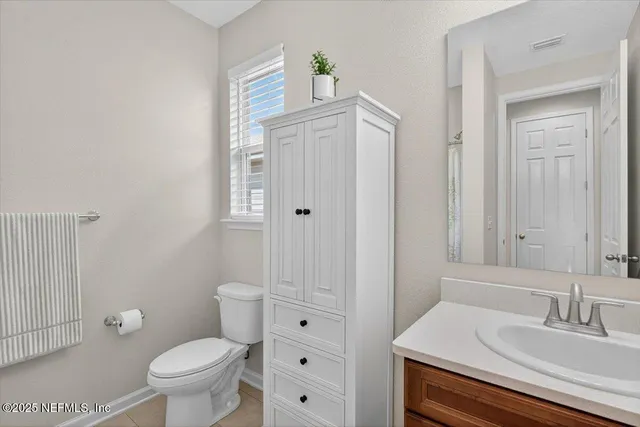 a view of a bedroom with wooden floor and a ceiling fan