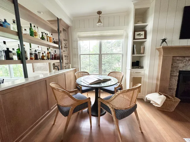 a kitchen with stainless steel appliances granite countertop a table chairs and a refrigerator