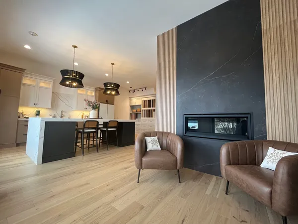 a kitchen with stainless steel appliances granite countertop a refrigerator a sink dishwasher a stove and white cabinets with wooden floor