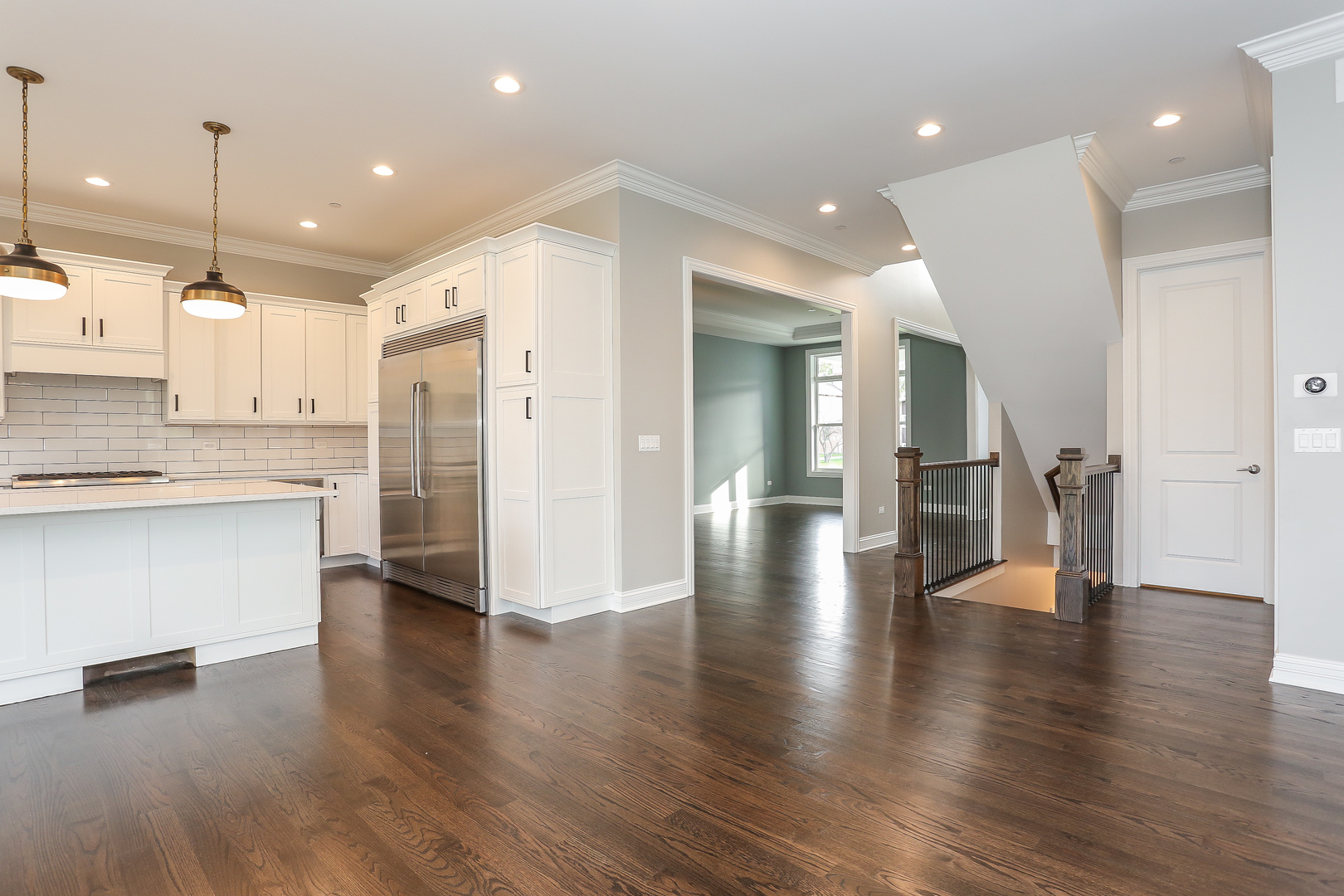 176 Red Leaf Circle Lakewood, IL 60014 - Photo 8 of 49 a view of an empty room and kitchen with window a ceiling fan and wooden floor