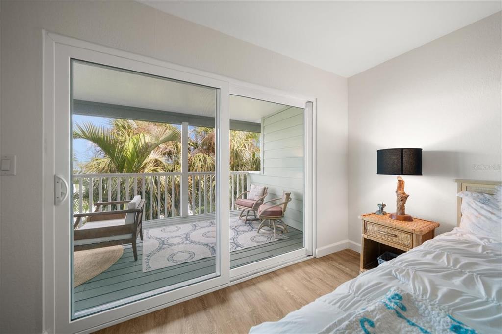 2505 Bay Boulevard, Unit 4 Indian Rocks Beach, FL 33785 - Photo 17 of 63 a bedroom with a bed and a glass door
