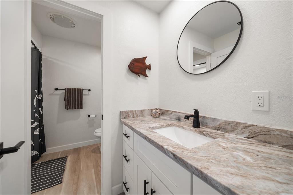 2505 Bay Boulevard, Unit 4 Indian Rocks Beach, FL 33785 - Photo 25 of 63 a bathroom with a granite countertop sink and a mirror