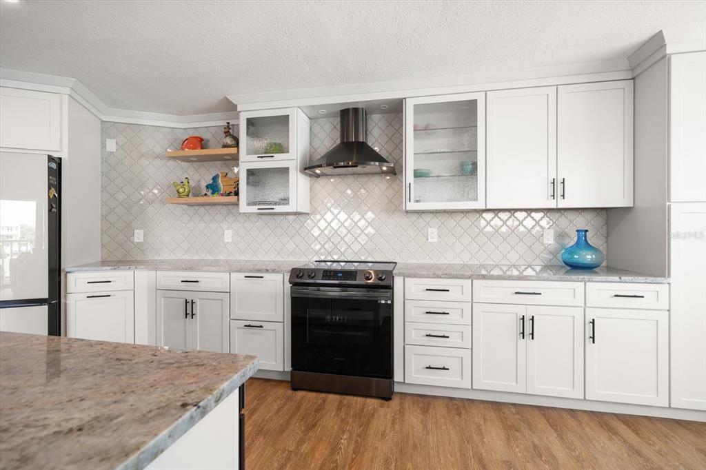 2505 Bay Boulevard, Unit 4 Indian Rocks Beach, FL 33785 - Photo 6 of 63 a kitchen with stainless steel appliances granite countertop a stove and cabinets