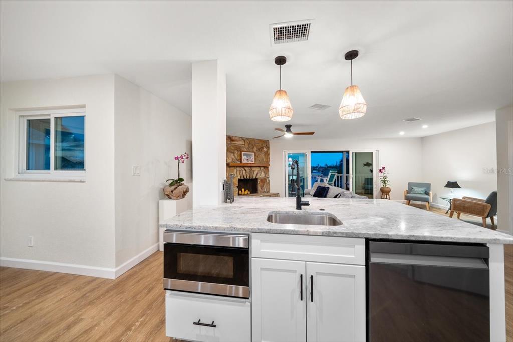 2505 Bay Boulevard, Unit 4 Indian Rocks Beach, FL 33785 - Photo 8 of 63 a kitchen with a sink dishwasher a dining table and chairs with wooden floor