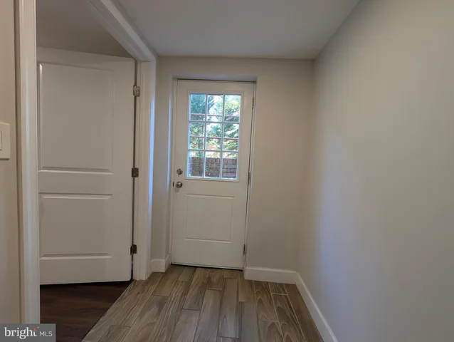 a view of small space with wooden floor and a window